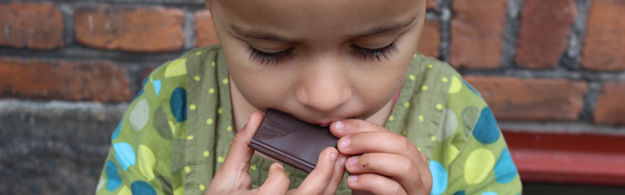 Lille pige smager på mørk chokolade. Foto: Patricia deCosta